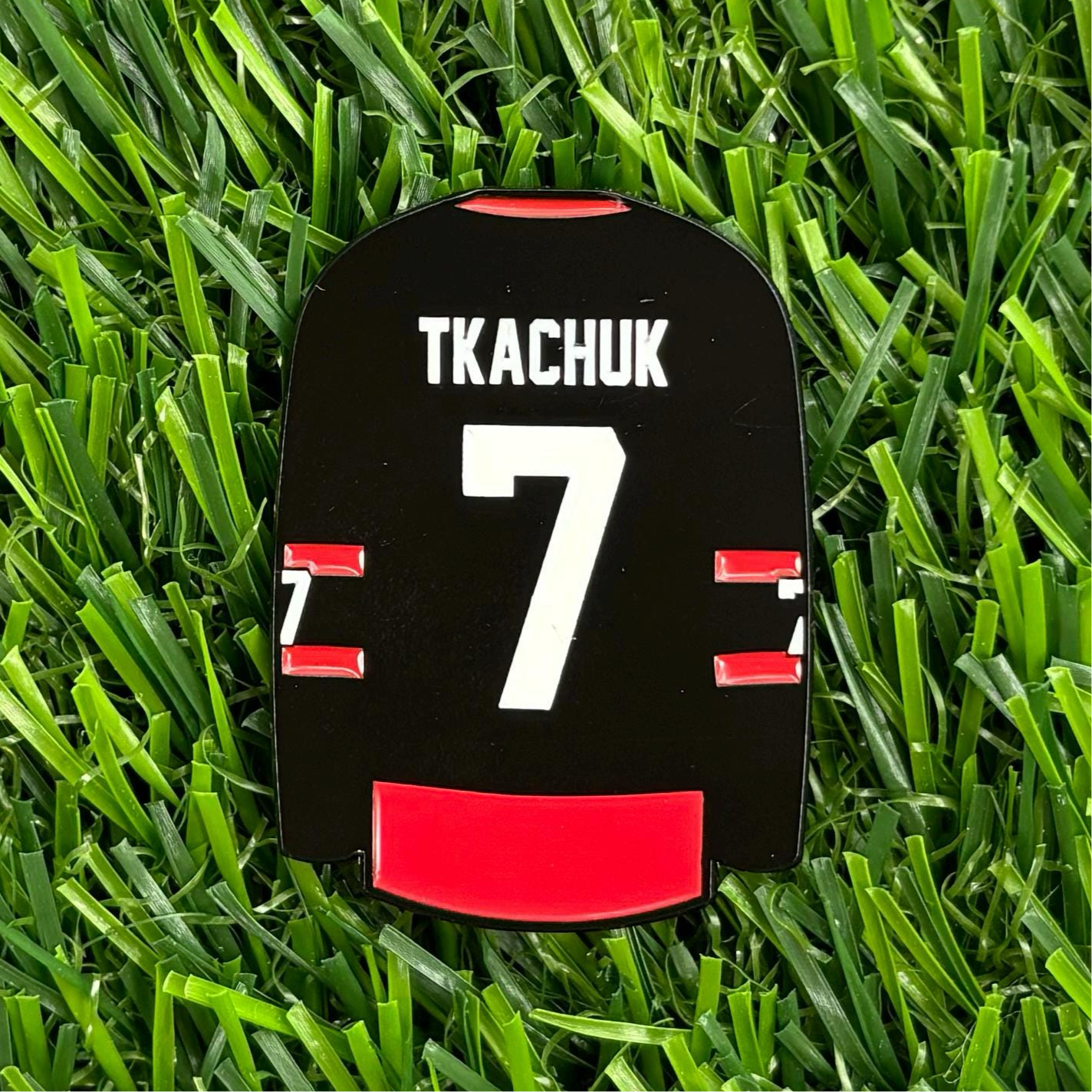 Sandybirds Golf Gear Tkachuk Ball Marker - Premium quality golf ball marker made of zinc alloy, designed in the shape of a Tkachuk jersey. A perfect accessory for golf enthusiasts looking to add a touch of style and precision to their game.