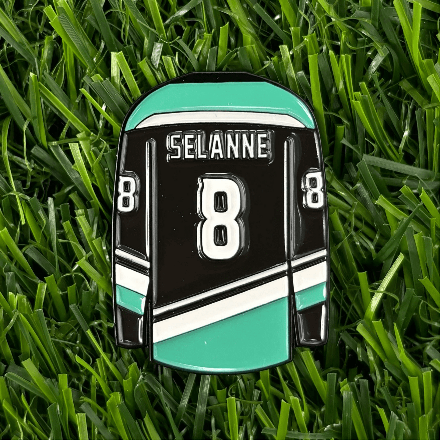 Teemu Selanne custom golf ball marker on grass, featuring jersey design with number 8, a unique and stylish golfing accessory