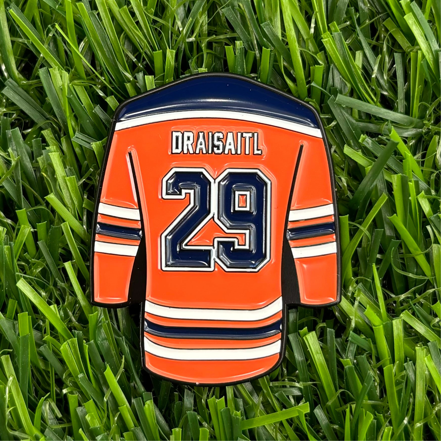 Leon Draisaitl custom ball marker shaped like a hockey jersey with number 29 on grass - premium golf accessory.