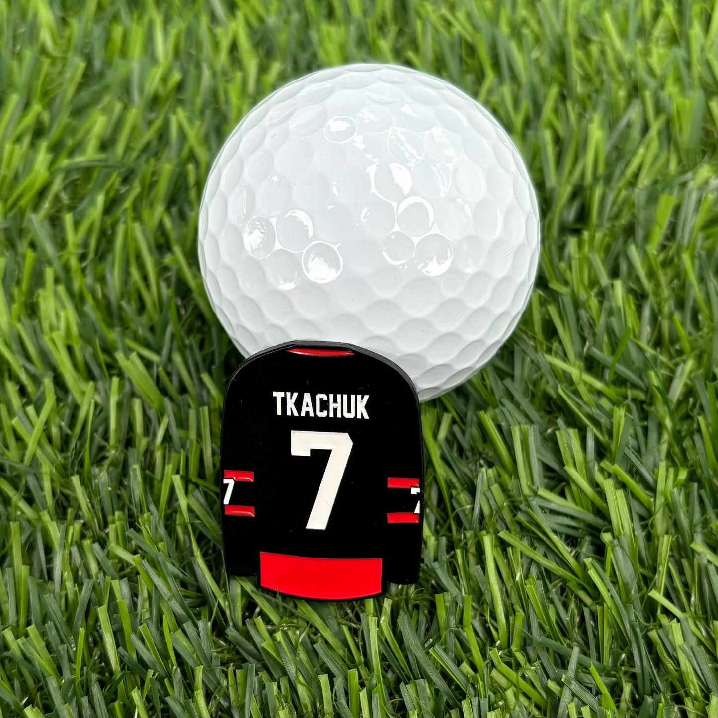 Sandybirds Golf Gear Tkachuk Ball Marker - Premium quality golf ball marker made of zinc alloy, designed in the shape of a Tkachuk jersey. A perfect accessory for golf enthusiasts looking to add a touch of style and precision to their game.