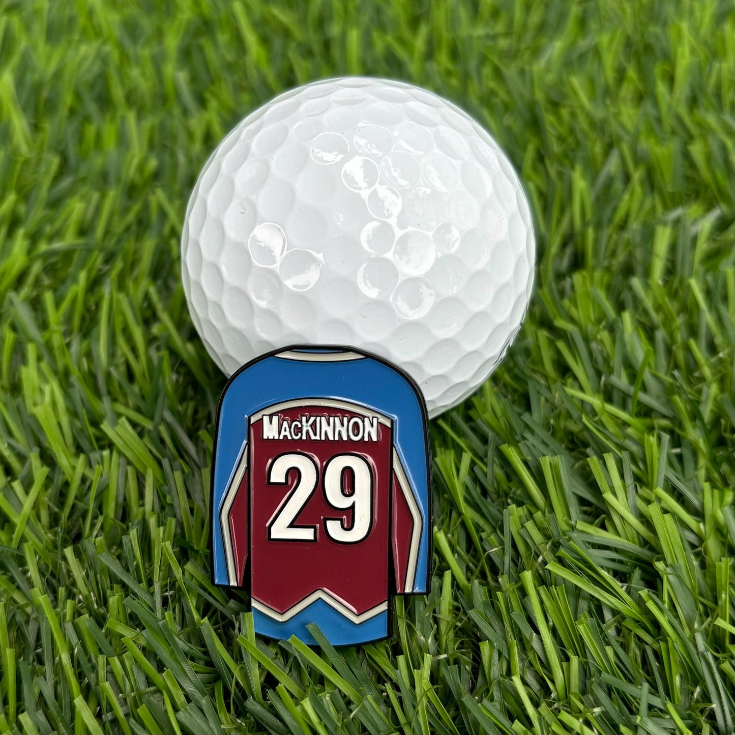 Nathan MacKinnon custom golf ball marker with jersey design on grass, premium golf accessory