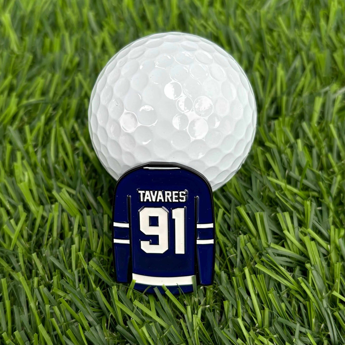 John Tavares golf ball marker on grass with golf ball, durable and stylish golf accessory for golfers, featuring jersey design.