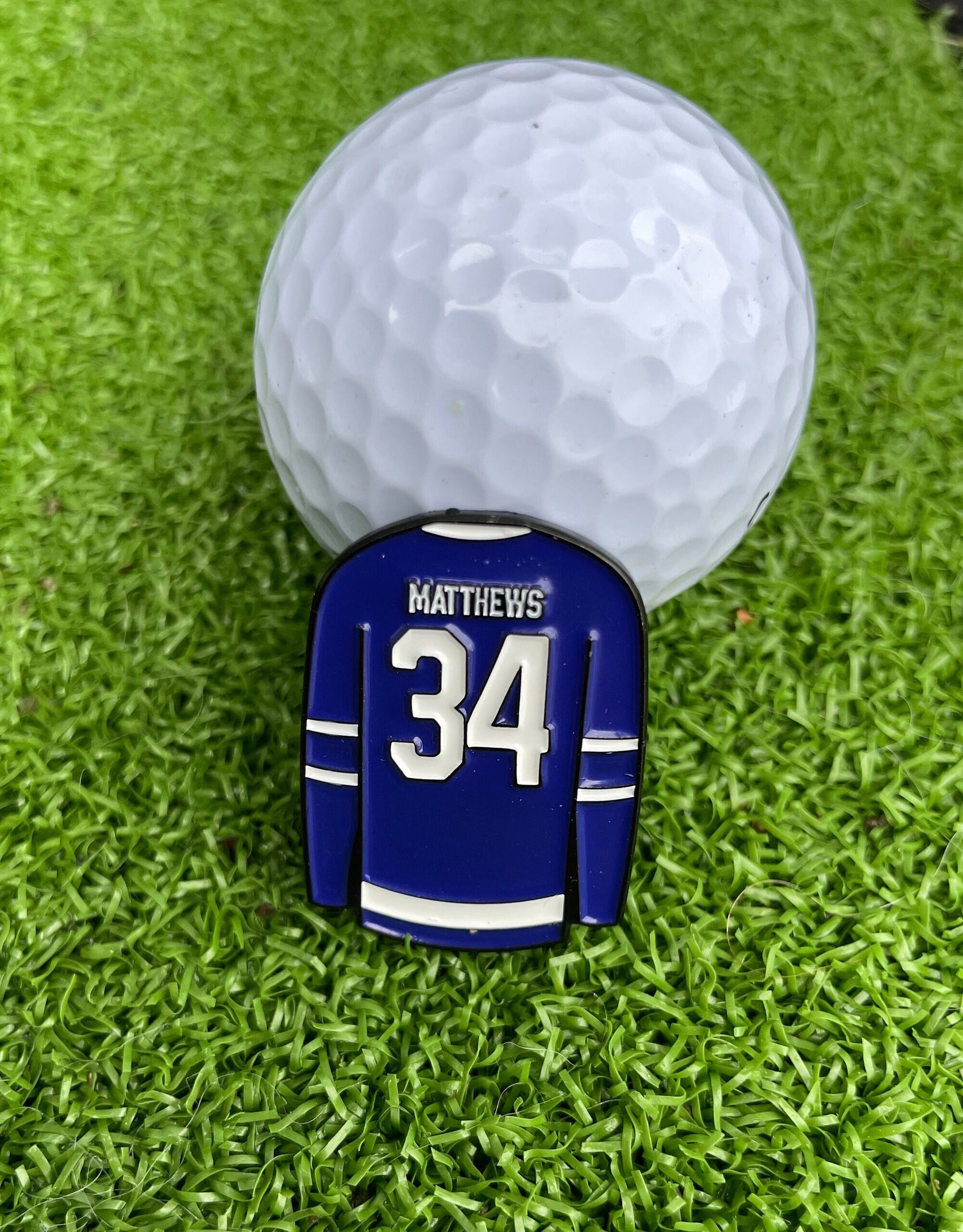 Sandybirds Golf Gear Matthews Ball Marker - Premium quality golf ball marker made of zinc alloy, designed in the shape of a Matthews jersey. A perfect accessory for golf enthusiasts looking to add a touch of style and precision to their game.